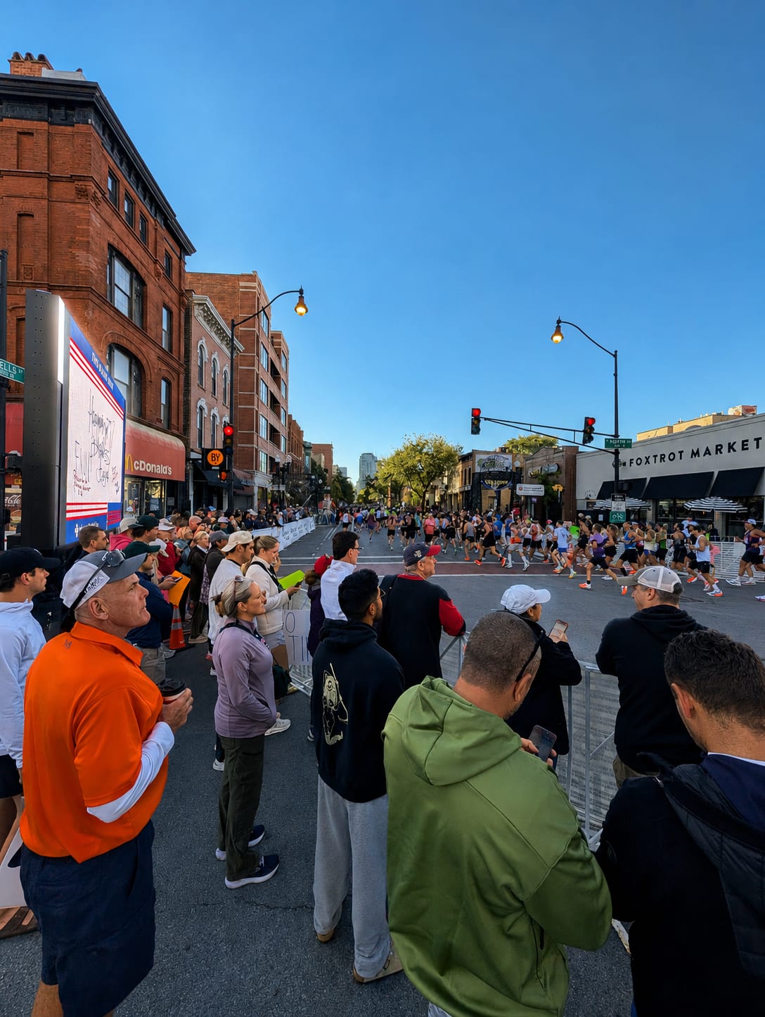 Spectators lining the Chicago Marathon course beside a Showtime LED screen