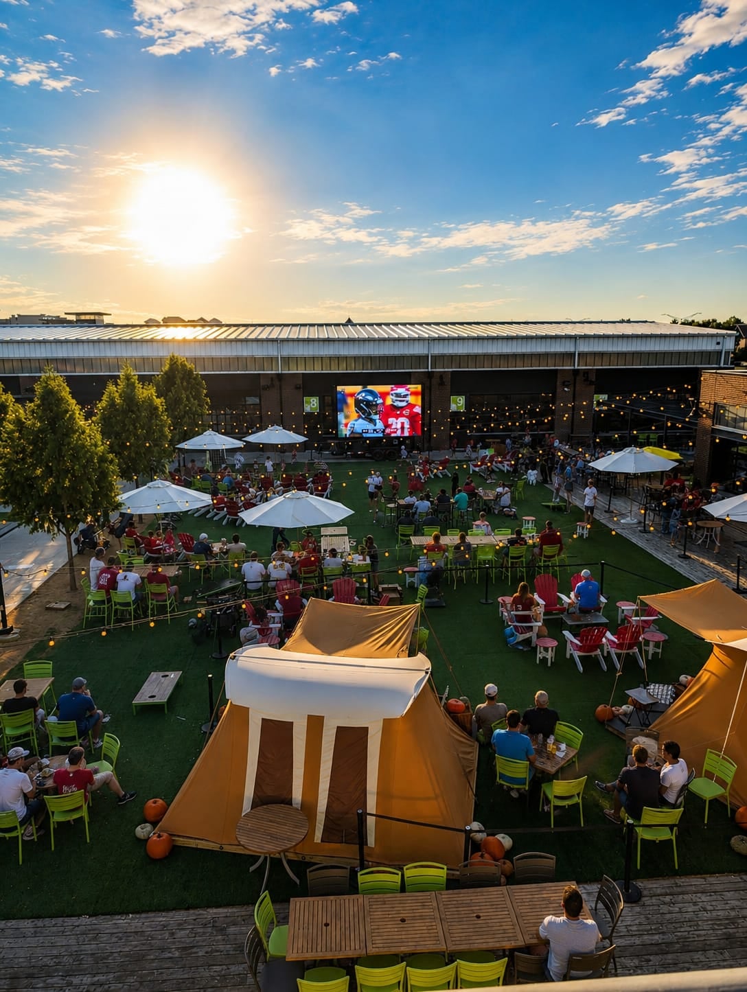 NFL watch party crowd on the lawn at Chicken N' Pickle watching a Showtime double-sided LED screen