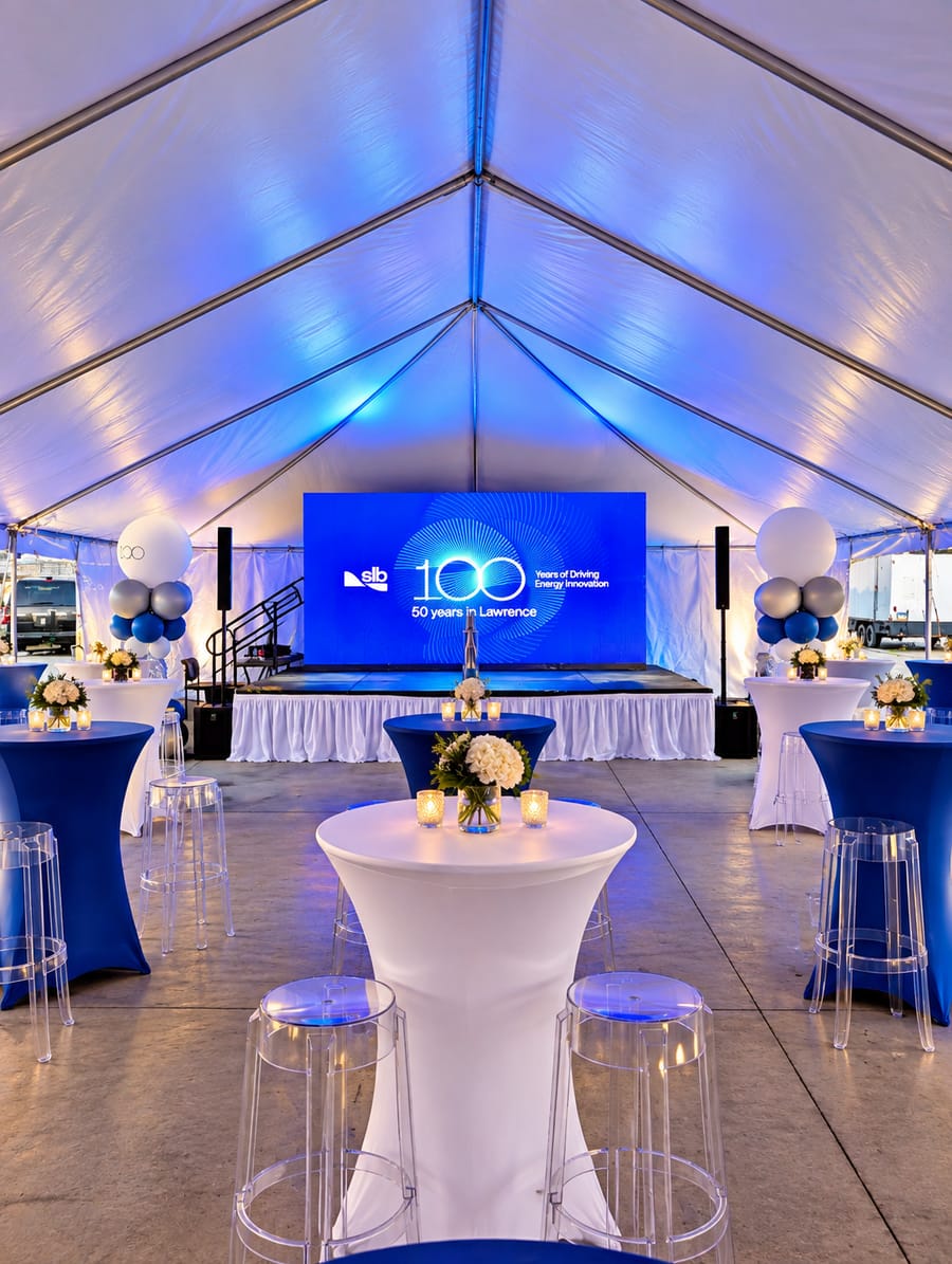 Showtime custom LED wall on a stage between speakers inside an event tent at a company anniversary celebration